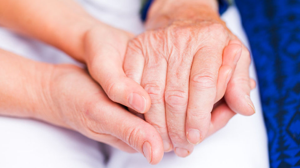Young hands holding an elderly persons hand